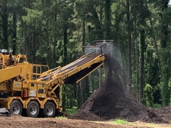 Industrial Scale Grinder with misting and deflection mitigations in use