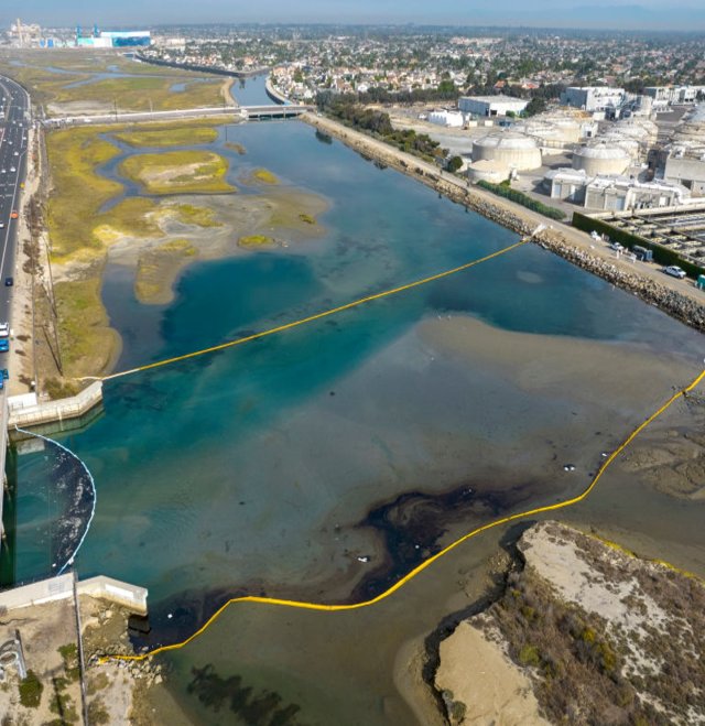 aerial photo above refinery showing oily sheen contamination into body of water