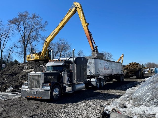 Large machinery loading soil into truck