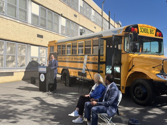 Adam Ortiz EPA Mid-Atlantic Regional Administrator speaking at podium in front of an electric school bus.