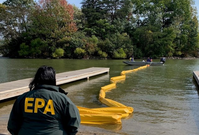 EPA crew lays yellow horizontal boom to protect boat ramps and collect debris.