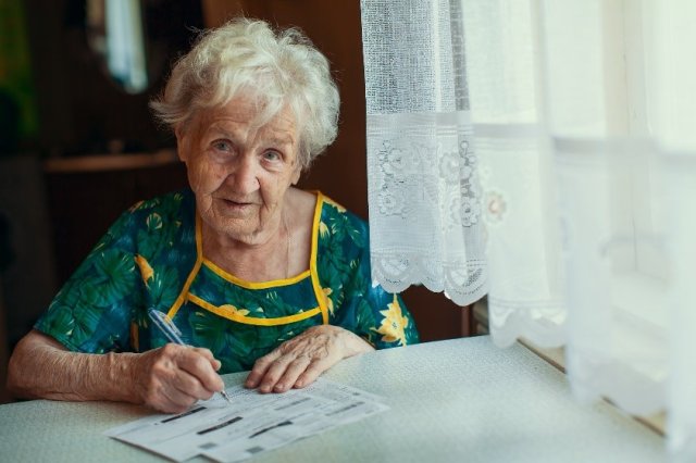 Woman sitting at table paying bills