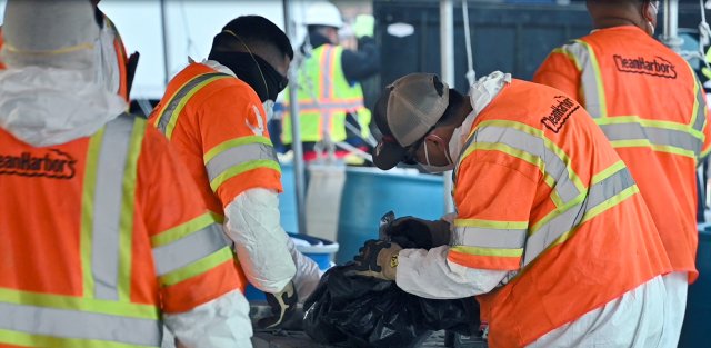 Workers unloading and sorting bagged and sealed waste.