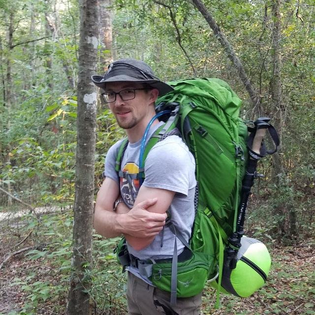 EPA chemist James McCord smiling while on a hike carrying a hike backpack