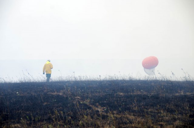 Researcher in a yellow jacket approaches a thick balloon used for the burn study