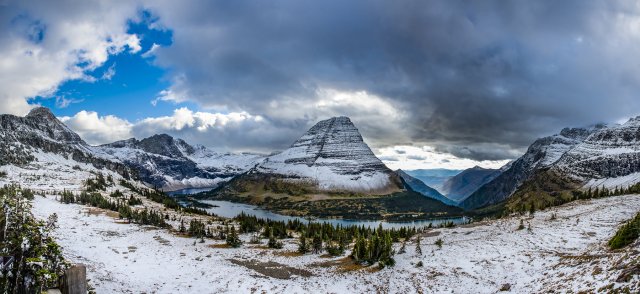 Lake and mountain peaks with dark clouds overhead.