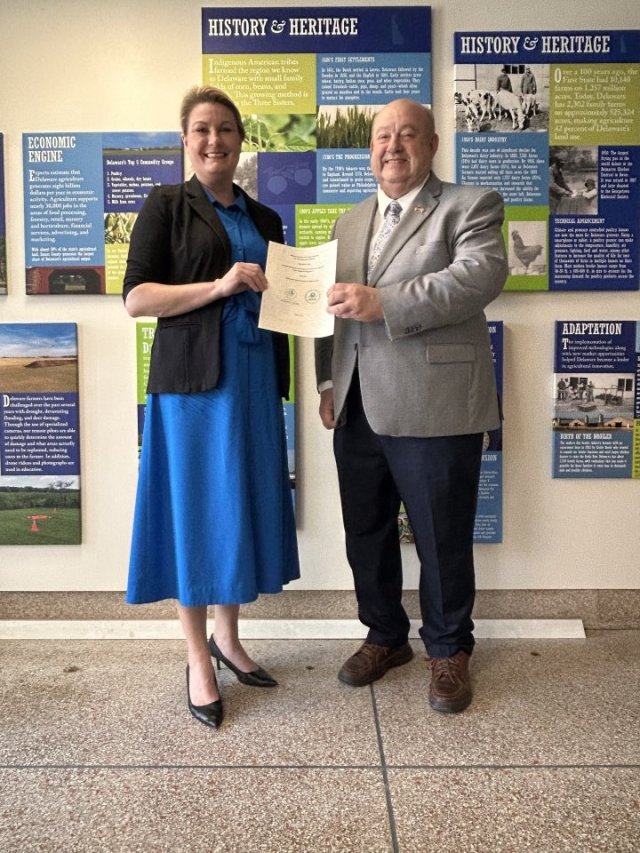 Officials smiling holding an agreement.