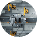 Round image with bird's eye view of car chassis being worked on by yellow robotic arms