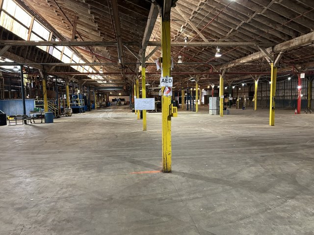 After photo of vats of chemicals used in the electroplating process, containers that the hazardous waste is stored in and, lastly, security measures in place. 