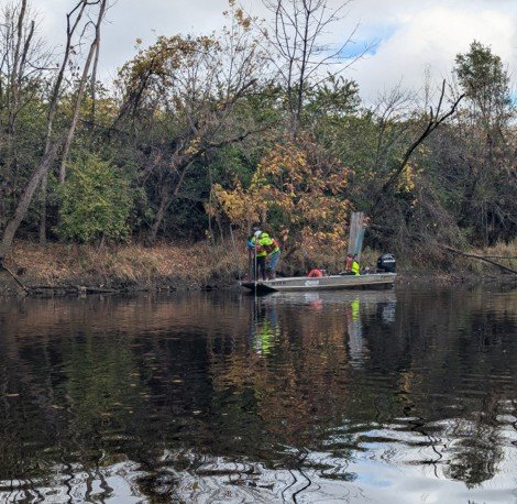 Three workers on a boat collect sediment samples in Ottawa Area 4X during the Fall 2024 Preliminary Design Investigation. 