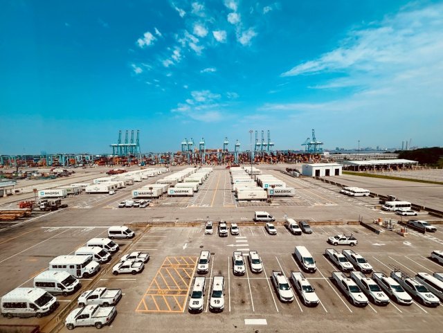 Busy port scene offloading a container ship with a fleet of vehicles 