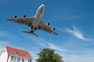 airplane flying over a house