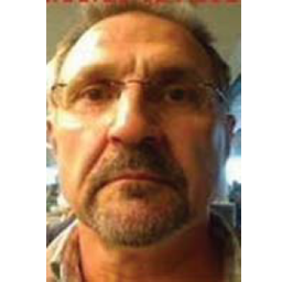 closeup of middle aged white male with facial hair and short haircut. frameless glasses