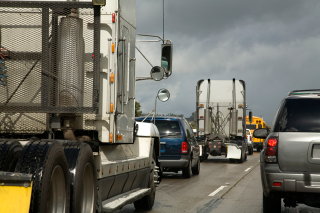 Cars and trucks driving on a highway.