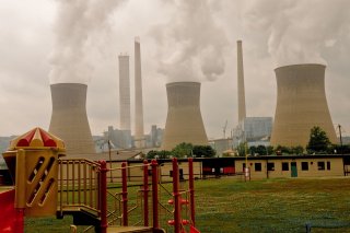 A playground is shown in the foreground with a power plant in the background