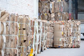 this is a warehouse with rows of bales of cardboard in it