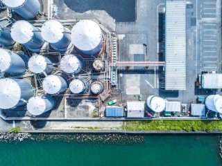 a bird's eye view of an industrial facility along a waterway