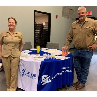 Two people standing in front of a table