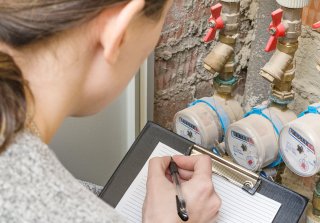 woman recording water meter 