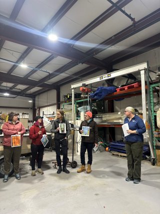 A few people stand in a circle at a site visit.