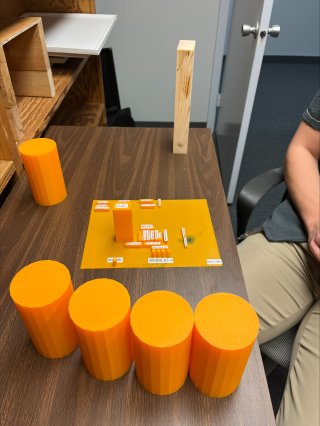 Mini-mock up of an oil and gas facility (back) and model cylinders (front)