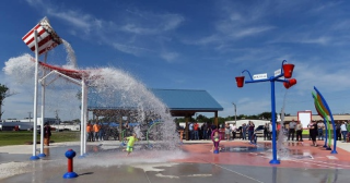 Children playing in water at a splash pad.