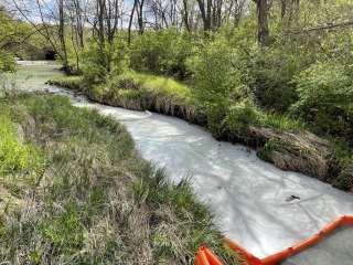 The impacted waterway with a containment boom.