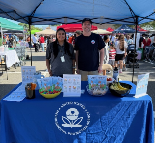 Two people standing behind a blue EPA booth.