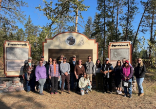 A group of people standing together in front of signs about the park.