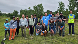 A group of people standing together in a field.
