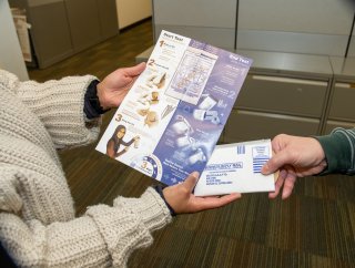 An individual receiving an illustrated pamphlet on how to use a radon test kit.