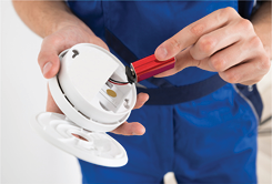a man holding a carbon monoxide alarm