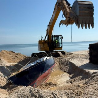 EPA excavating the abandoned boat out of the sand on Westwoods Beach. 