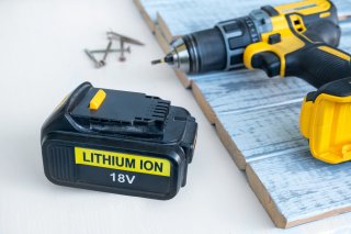 a lithium ion battery sitting next to the drill that it came from