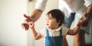 Child walking while holding adult's hand