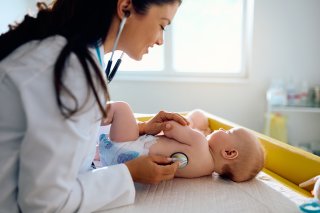 Baby getting a checkup by a medical professional