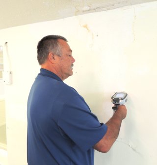 Man using an XRF gun to test for lead paint