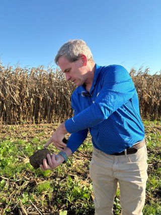 Farmer holding soil upclose on a farm.