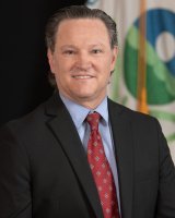 Head and shoulders portait of Mark Smith in front of the EPA flag.