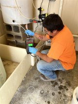Seymour Brandt, Santee Sioux Tribal water operator, adjusts the drinking water system's disinfection pump.