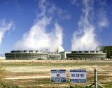 daytime view of nuclear power plant behind a chain link fence