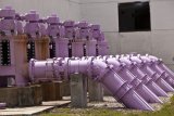 set of industrial scale purple water pipes connected to a building and continuing underground